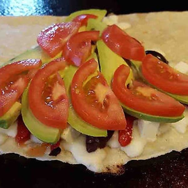 Savory crepe from The Crepery, filled with sliced tomatoes, avocado, and creamy white cheese.